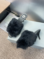 Black faux-fur slide sandals with open toe and tall stiletto heel.