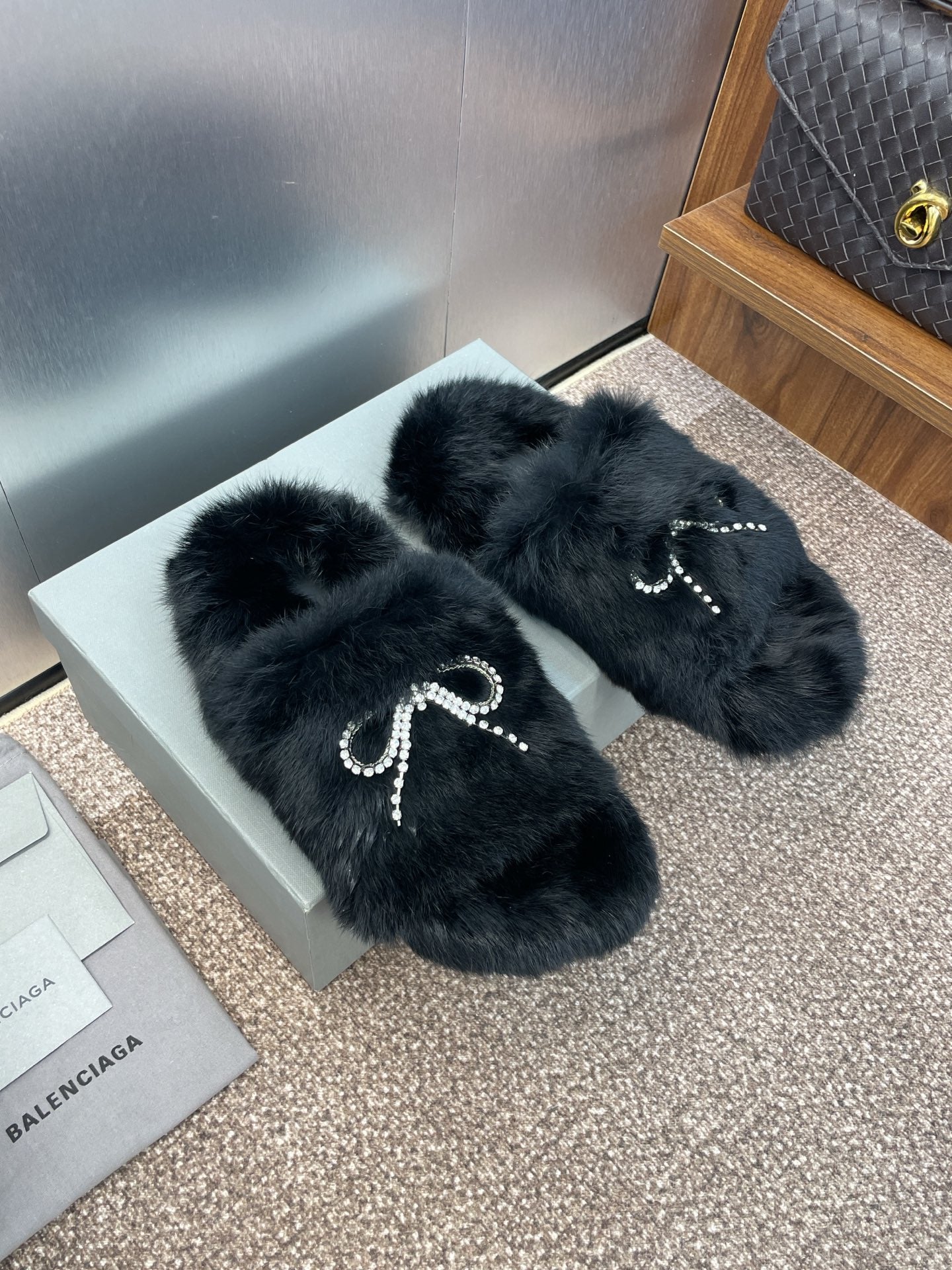 Balenciaga black faux-fur slide sandals with rhinestone bow embellishment