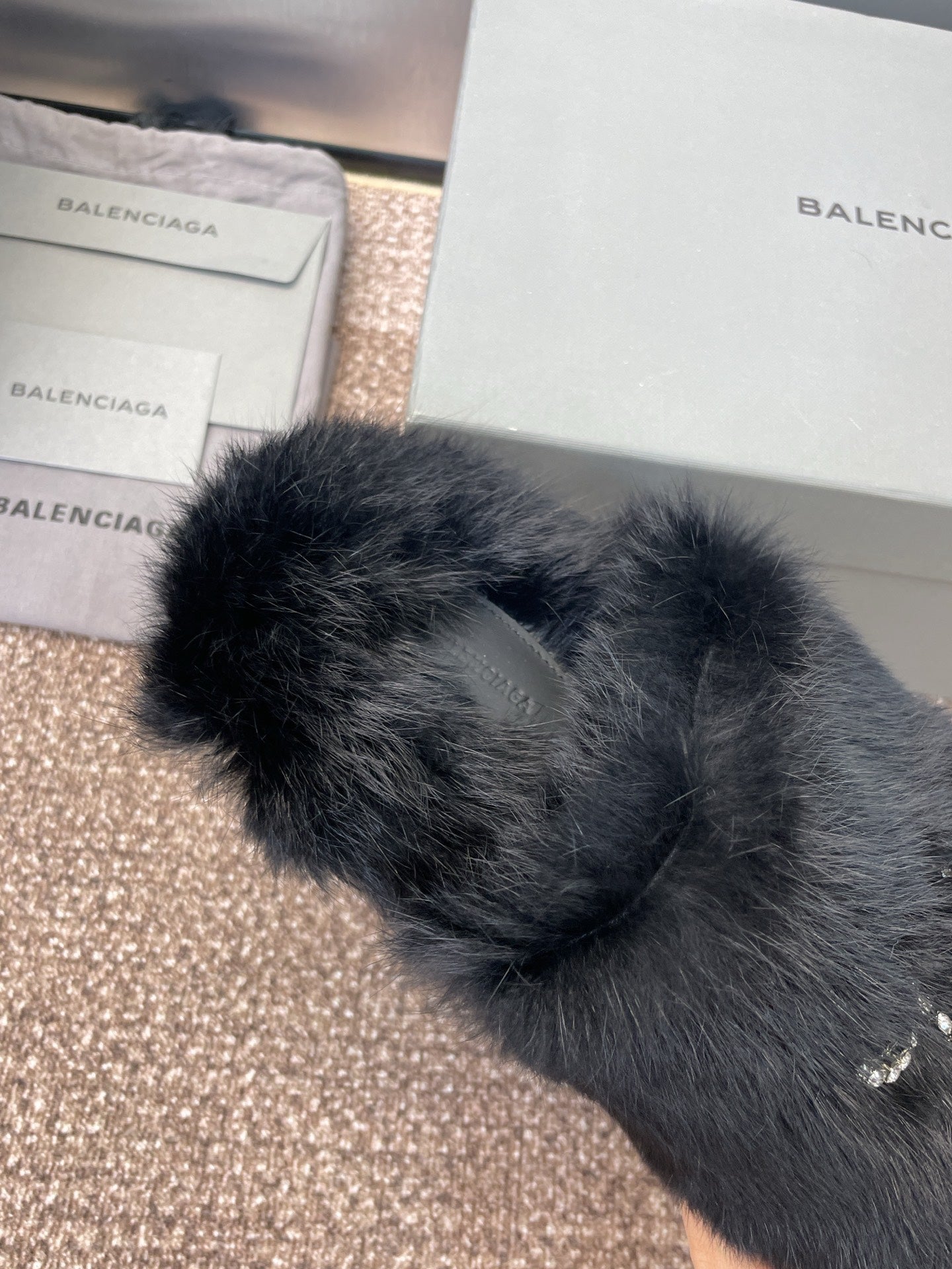 Balenciaga black fur slide sandals with rhinestone embellishment at strap