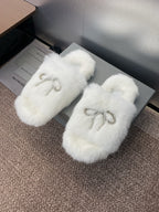 White fur slide sandals with rhinestone bow detail on the front