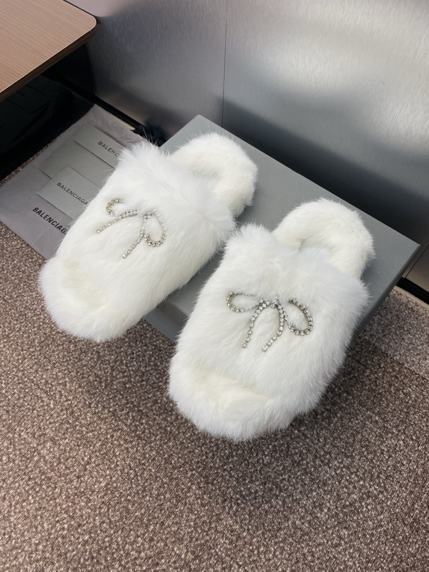 White fur slide sandals with rhinestone bow detail on the front