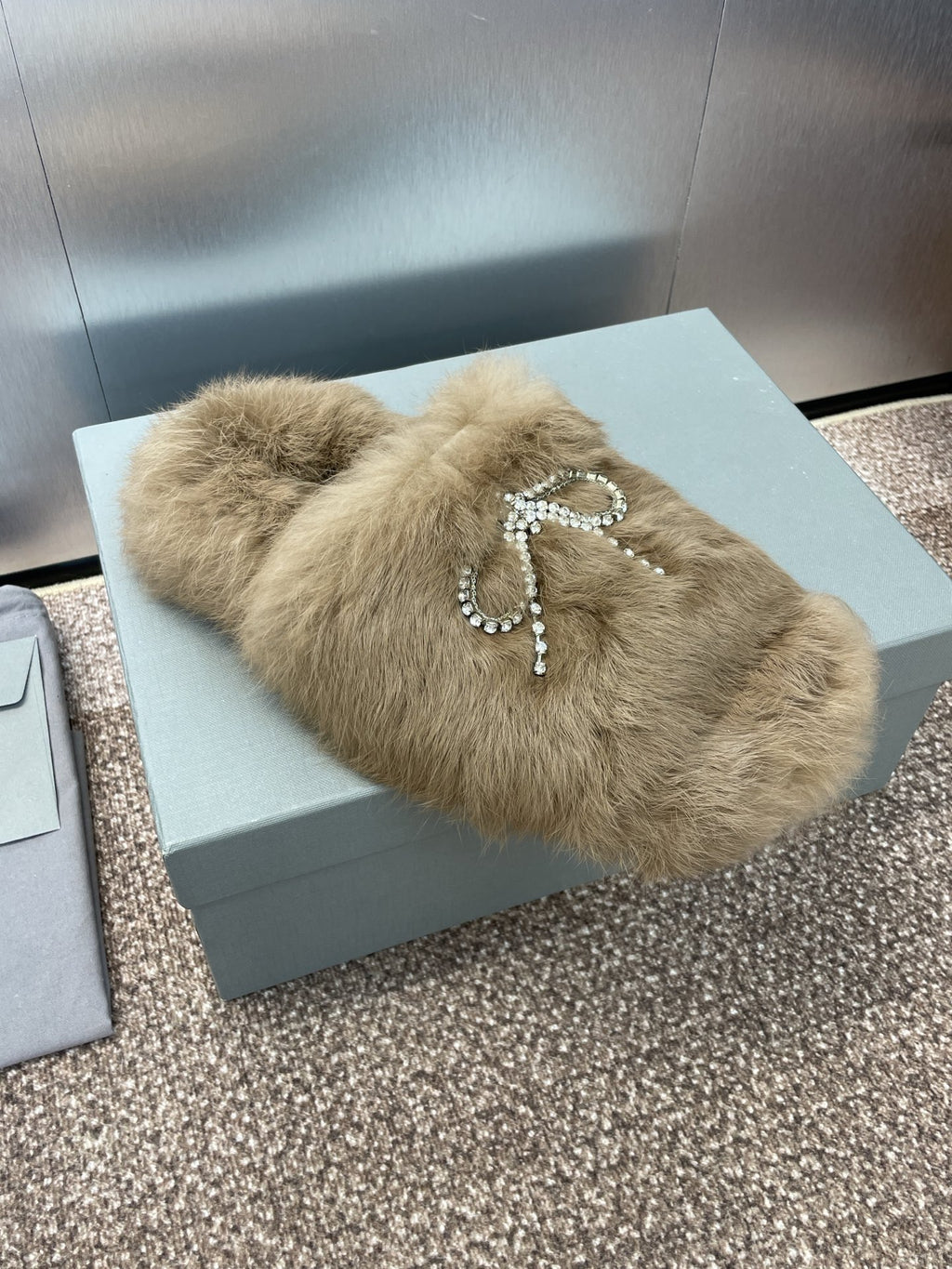 Tan fur slide sandals with rhinestone bow charm on the front strap