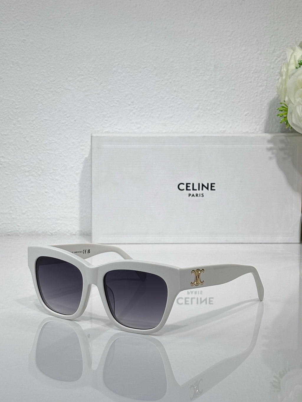 Celine sunglasses with light gray frames and dark lenses, gold logo on temple
