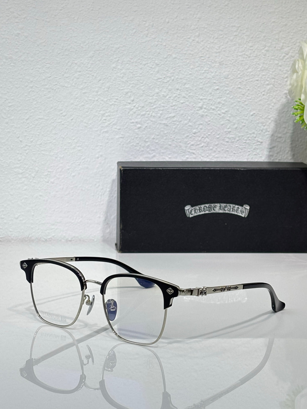 Chrome eyeglasses with black frames and clear lenses, angled side view