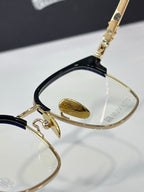 Close-up side of chrome eyeglasses with gold frame and clear lenses