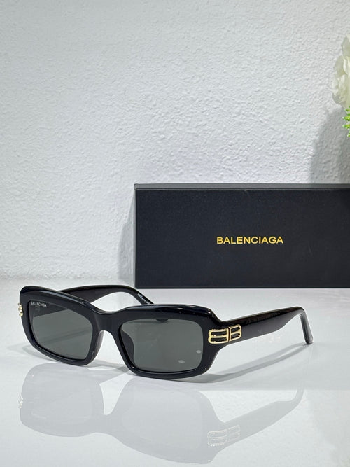 Balenciaga sunglasses with black frames and dark gray lenses, gold logo on temples