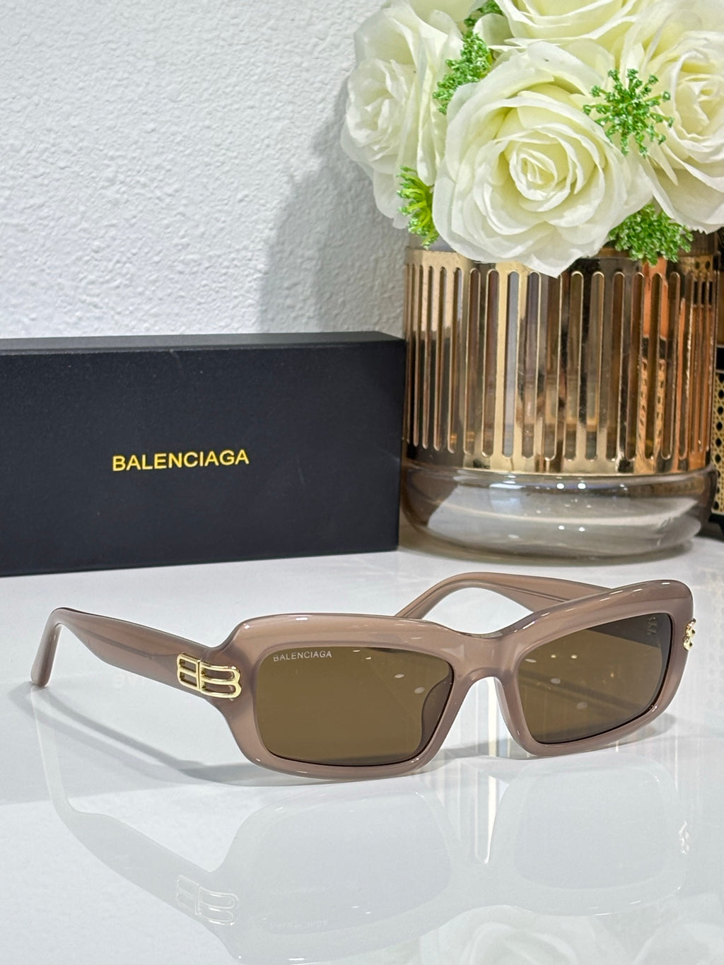 Balenciaga sunglasses with light tan frames and brown lenses, gold logo on temples