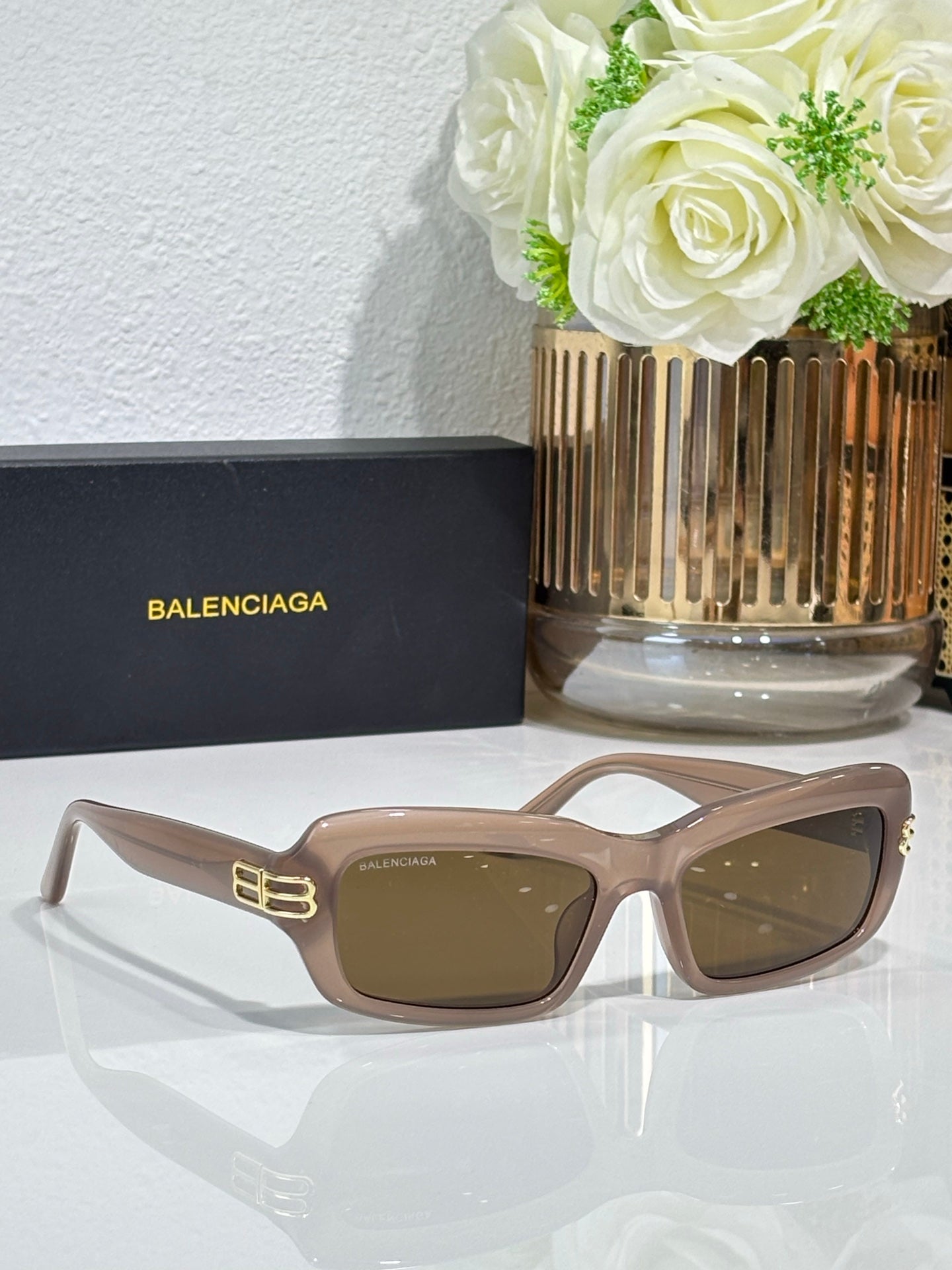 Balenciaga sunglasses with light tan frames and brown lenses, gold logo on temples