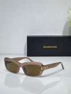 Balenciaga sunglasses with taupe-brown frames and brown lenses, gold logo on temples