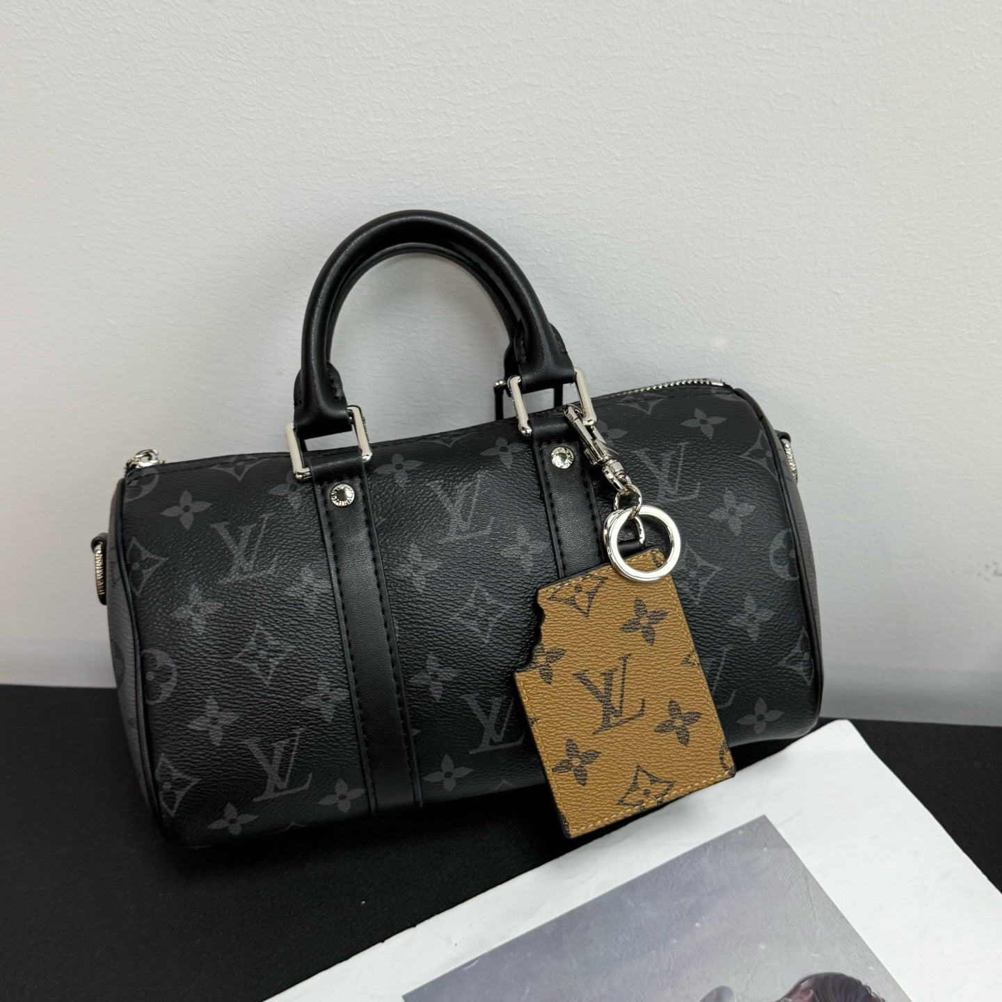 Louis Vuitton monogram handbag with black handles and detachable tan monogram keychain card