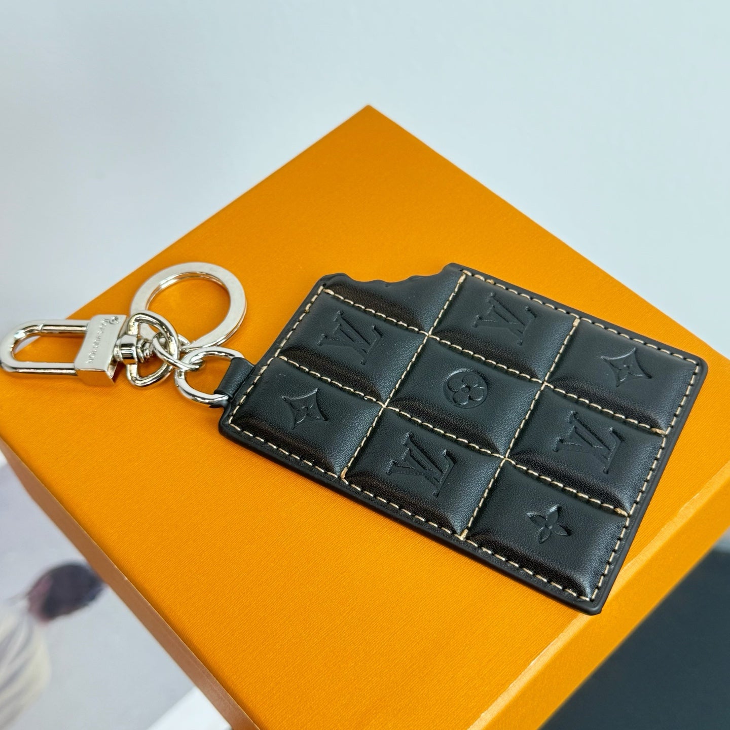 Louis Vuitton key holder in dark leather with stitch pattern and keyring