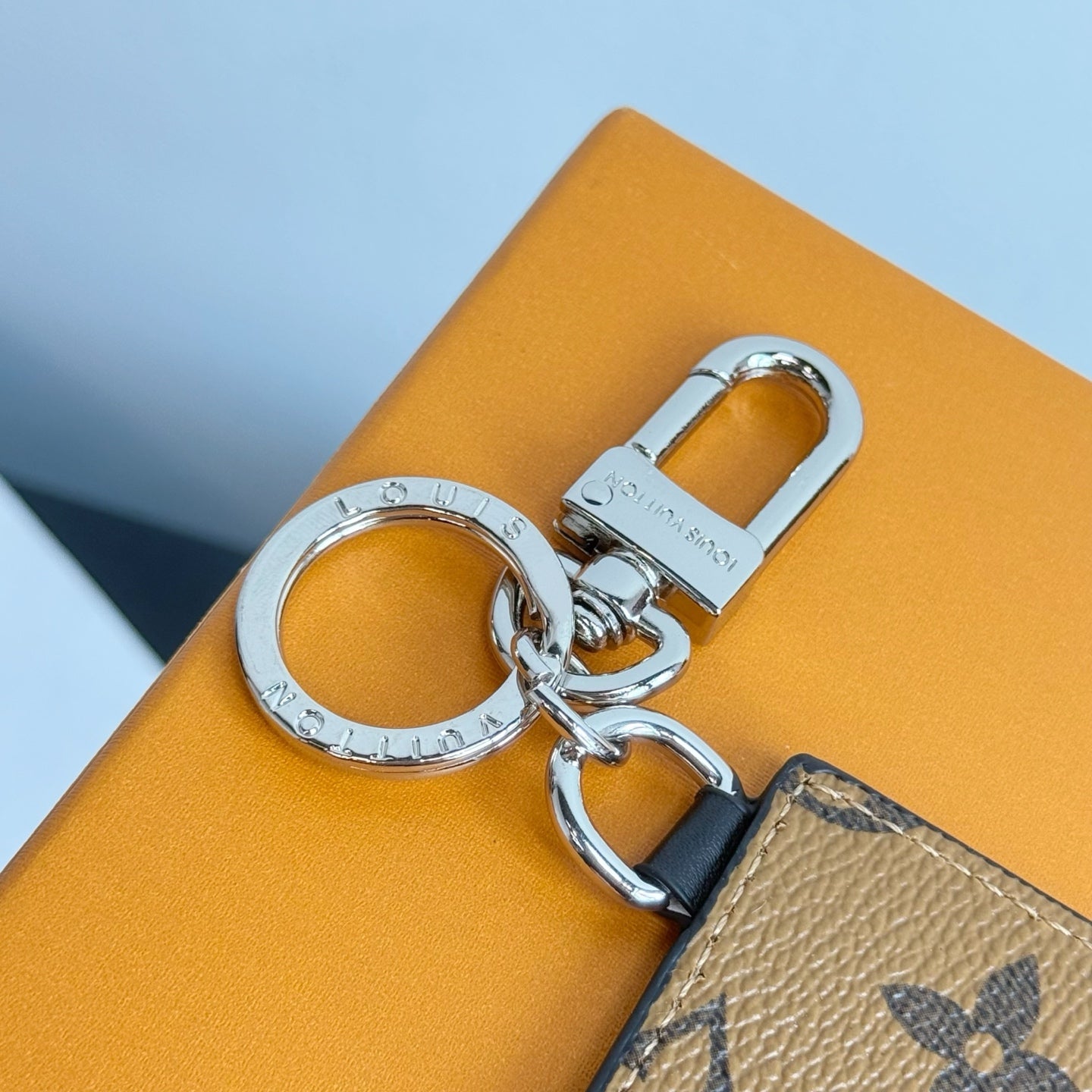 Louis Vuitton key holder close-up with chrome rings and tan monogram strap