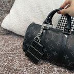 Louis Vuitton key holder with dark monogram pattern and stitched black trim