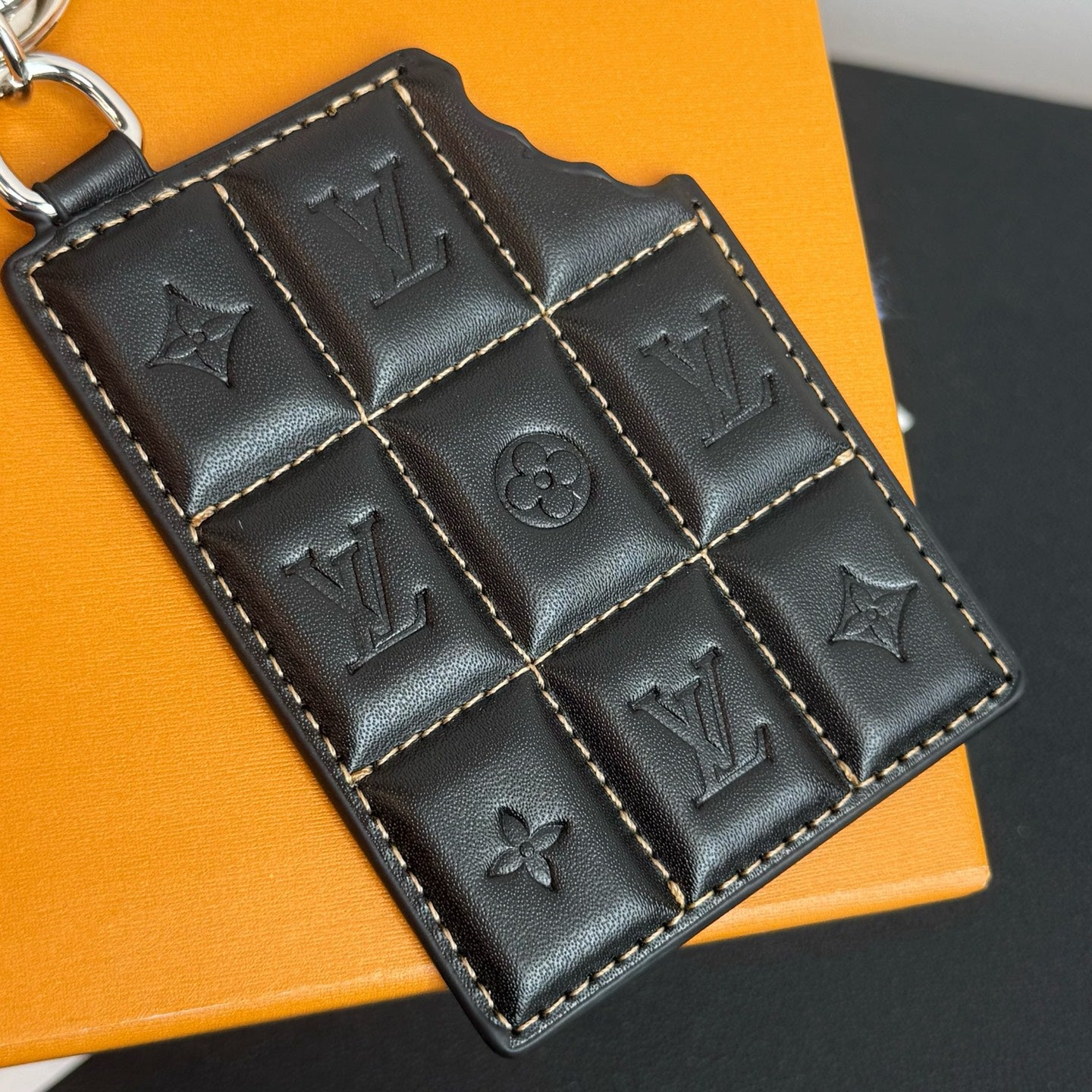 Louis Vuitton key holder in black leather with embossed LV symbols and quilting