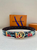 Louis Vuitton belt with dark monogram strap and multicolor floral pattern, gold-tone buckle.