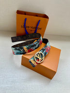 Louis Vuitton belt with floral-printed strap and gold-tone oval LV buckle.