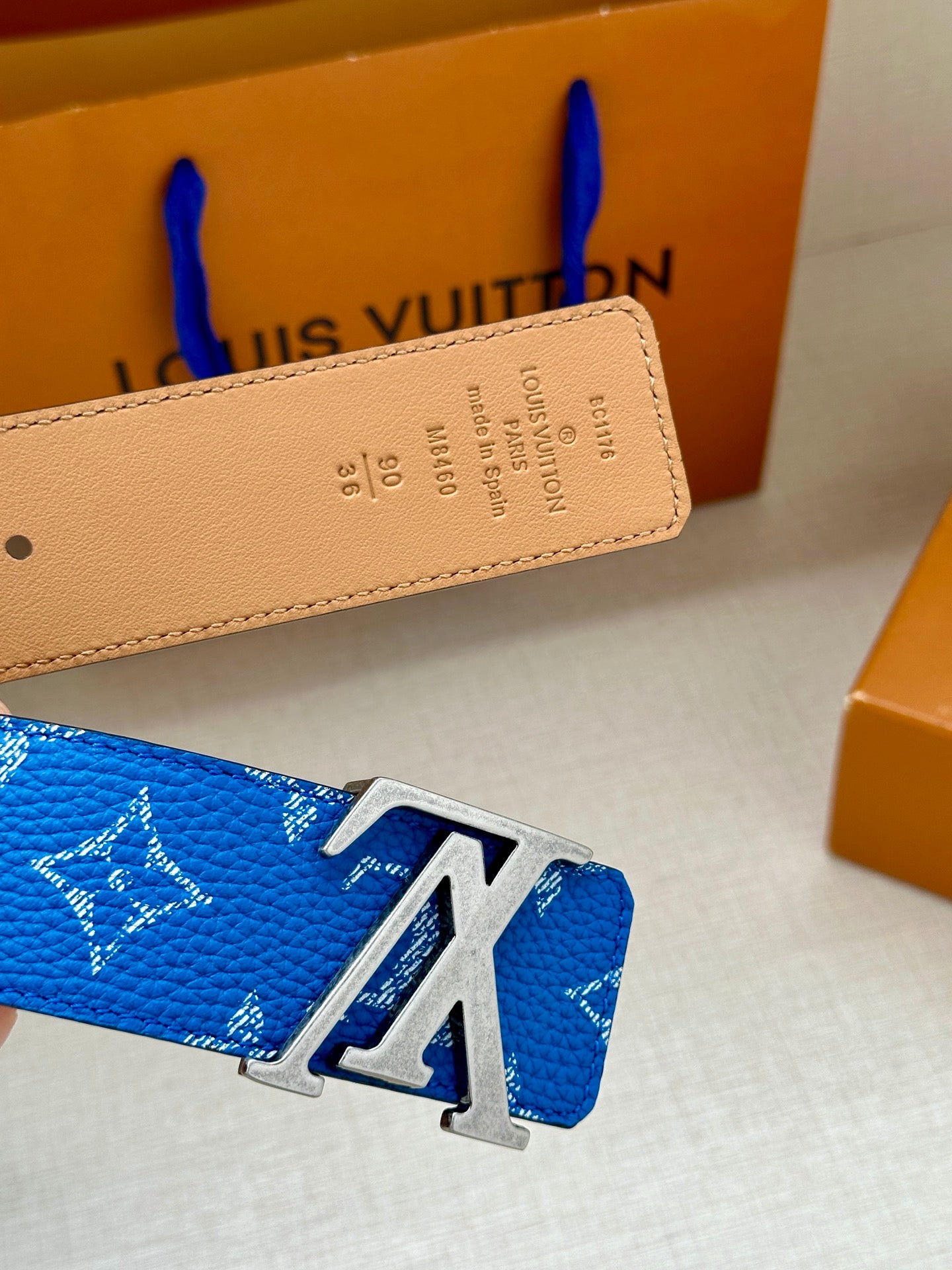 Blue monogram belt with silver LV buckle and tan leather strap detail