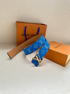 Blue monogram belt with tan leather strap and silver LV buckle, folded