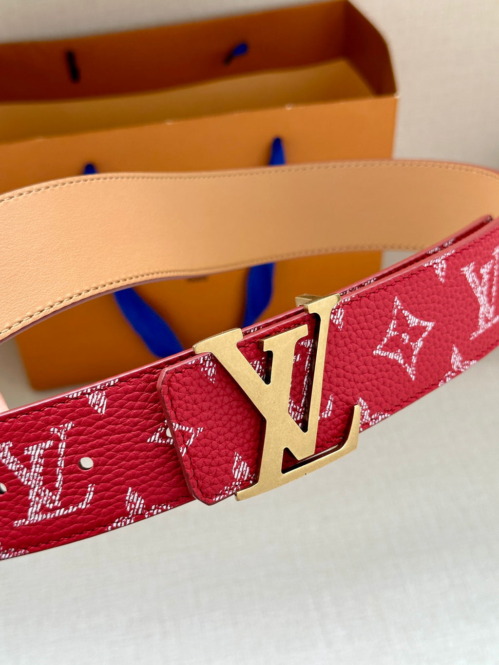 Louis Vuitton red monogram belt with gold-toned LV buckle, tan leather lining