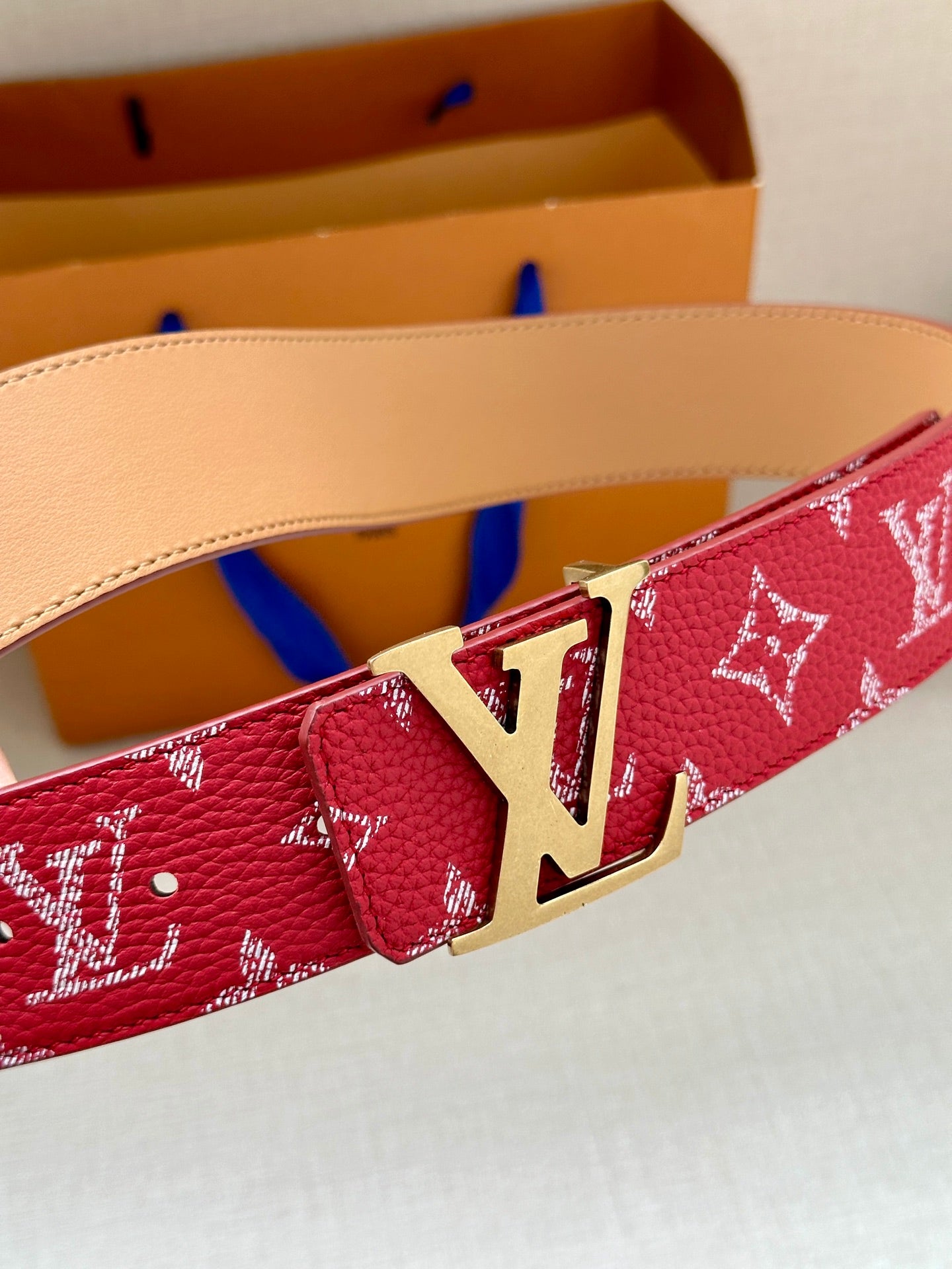 Louis Vuitton red monogram belt with gold-toned LV buckle, tan leather lining
