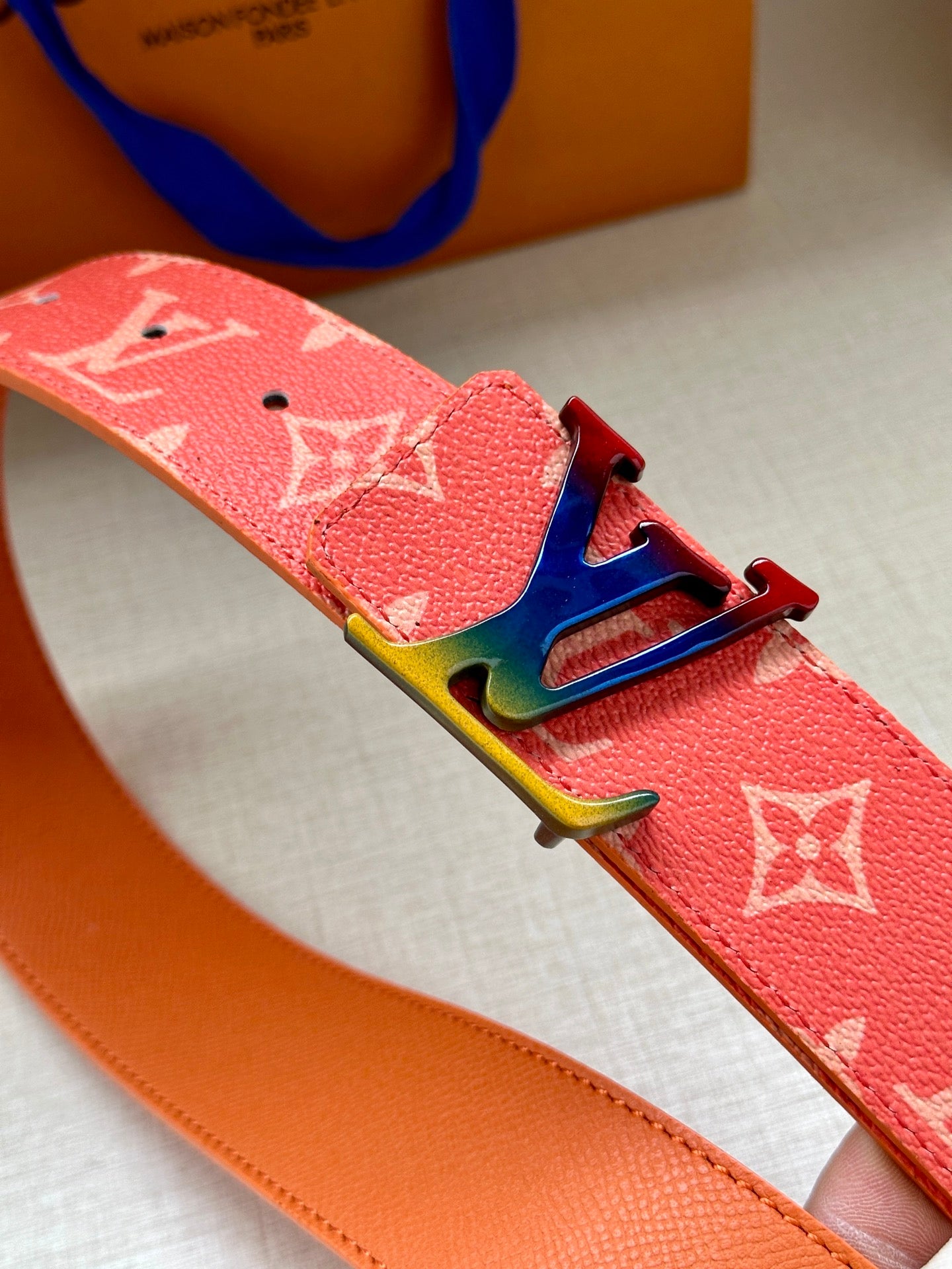 Pink Louis Vuitton monogram belt close-up with multicolor LV buckle