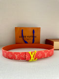 Louis Vuitton belt with red monogram print and gold-tone LV buckle, on display tray.