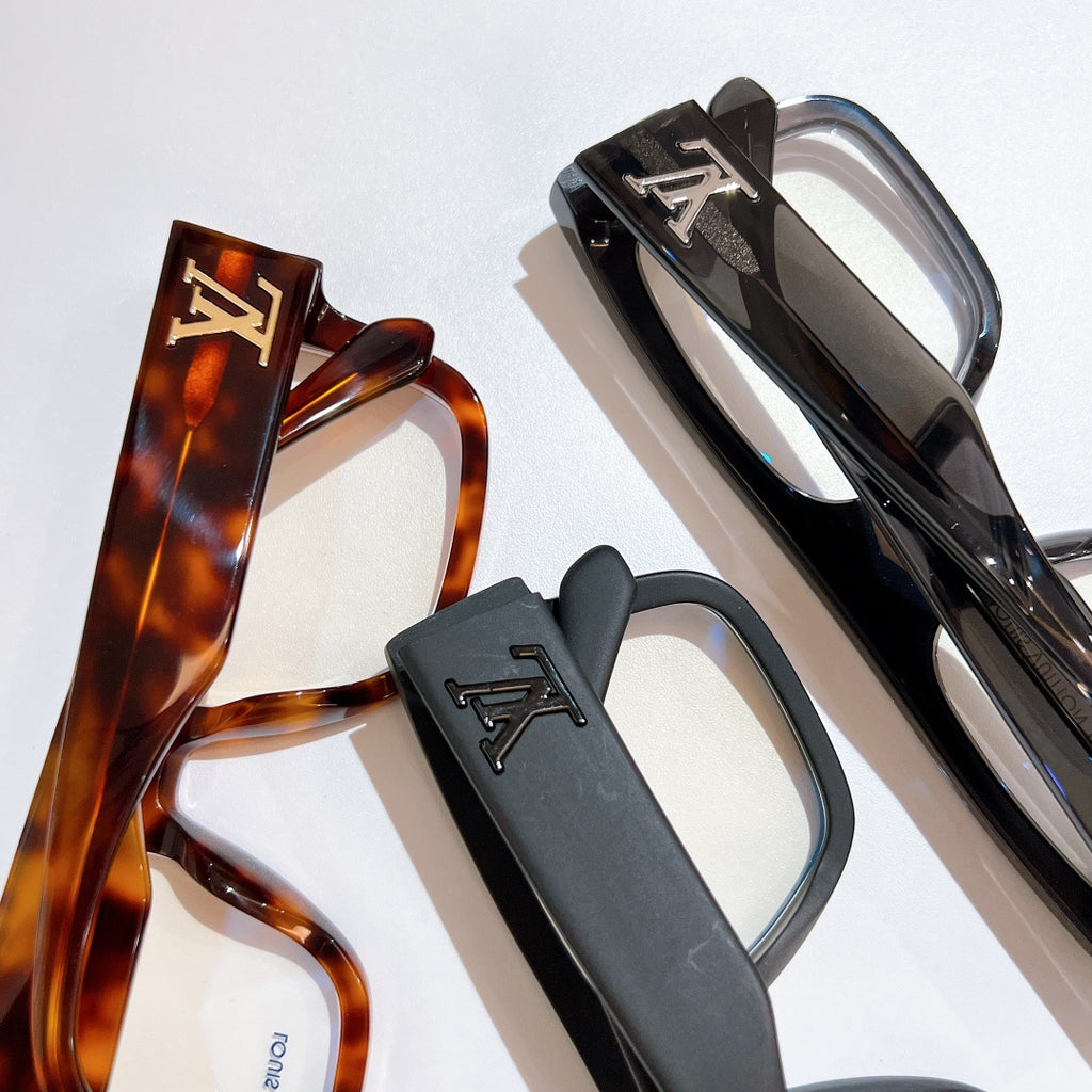 Two Louis Vuitton eyeglasses: tortoiseshell frame and black frame with LV details, clear lenses