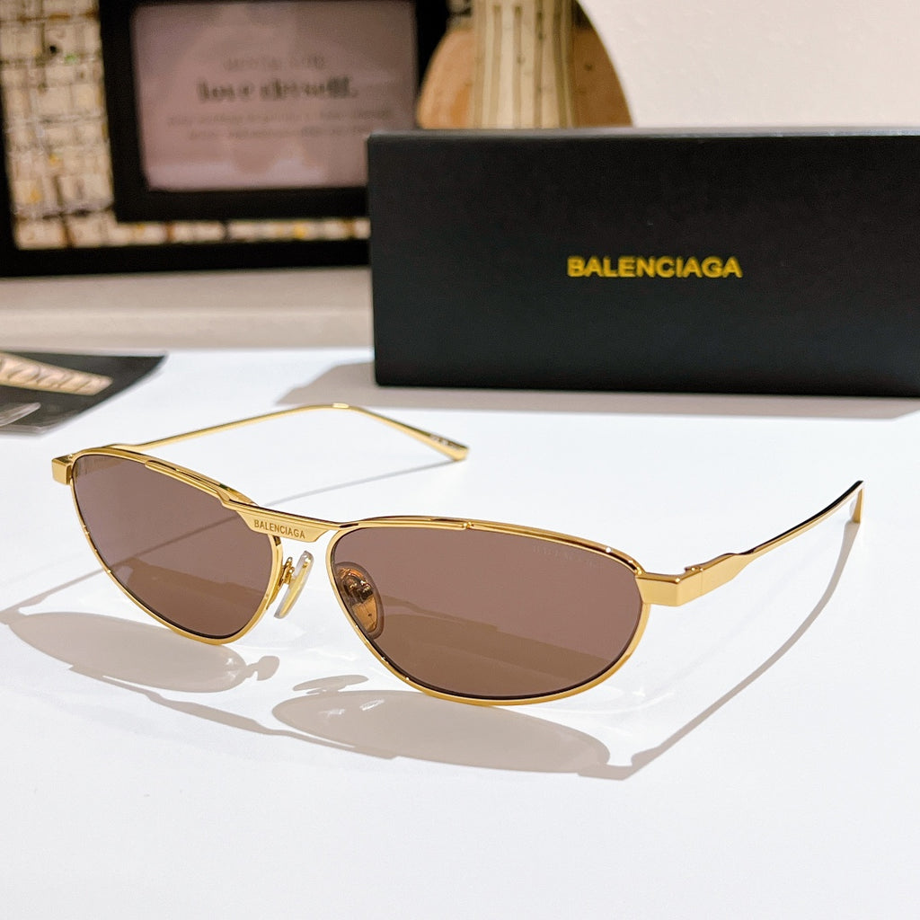 Oval brown tinted sunglasses with gold metal frame and thin temples