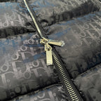 Gold zipper hardware on Dior logo puffer jacket, gray-blue monogram pattern, close-up.