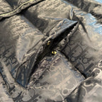 Long puffer jacket with Dior monogram pattern and gold snaps at placket, close-up.
