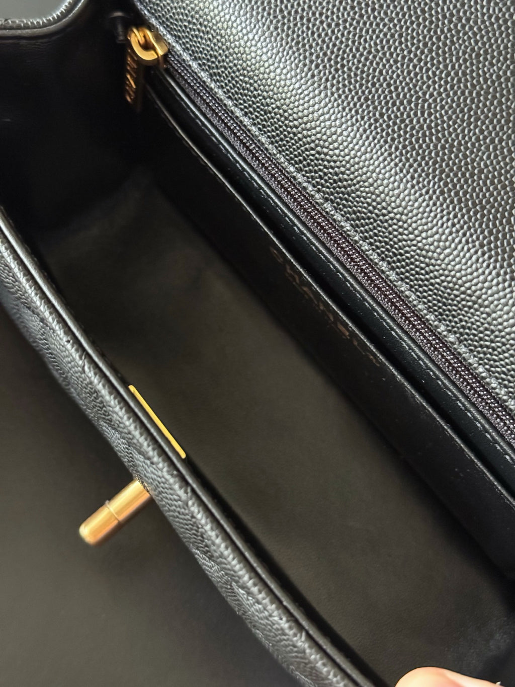Chanel mini handbag interior view with zip pocket, black leather and gold hardware