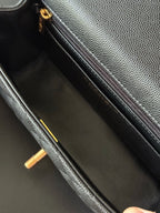Chanel mini handbag interior view with zip pocket, black leather and gold hardware