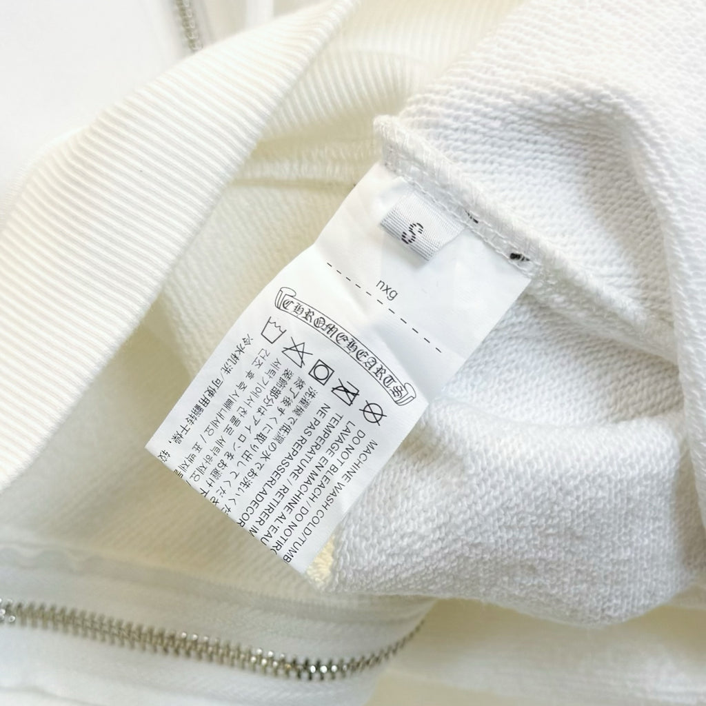 White long-sleeve garment with zipper and size label