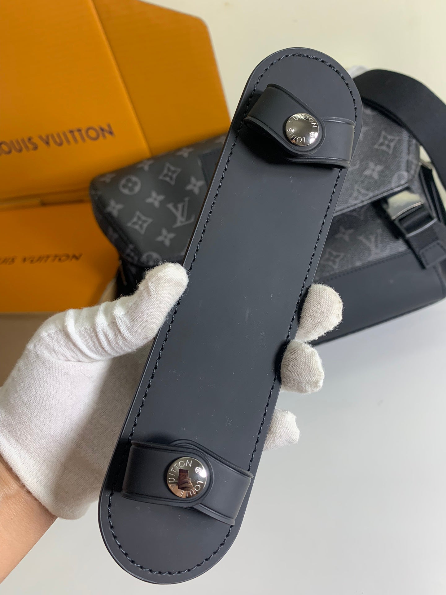 Louis Vuitton leather phone case-style bag with metal snap buttons and stitched edges