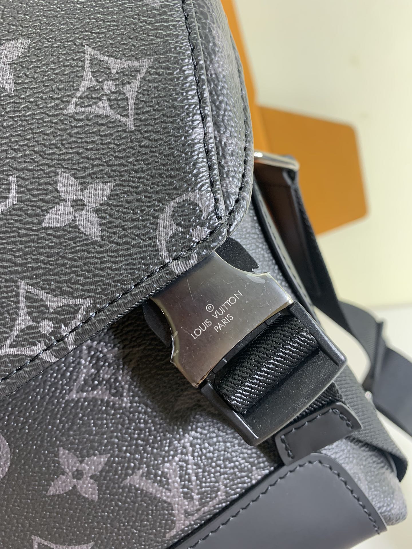 Louis Vuitton monogram crossbody bag close-up of strap buckle on textured leather