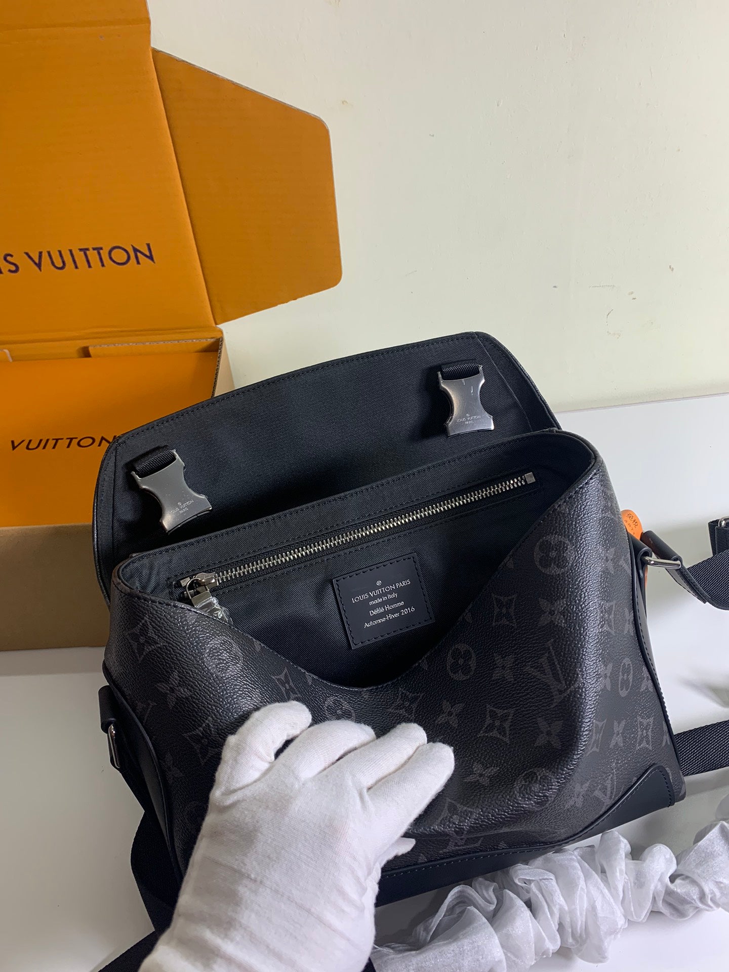 Louis Vuitton monogram shoulder bag with top handle, front zip pocket, and dark hardware