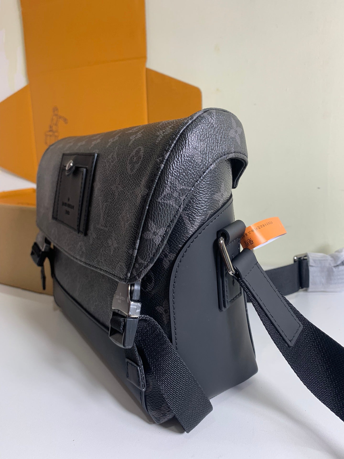Louis Vuitton textured leather flap bag with side pocket and metal clasp hardware