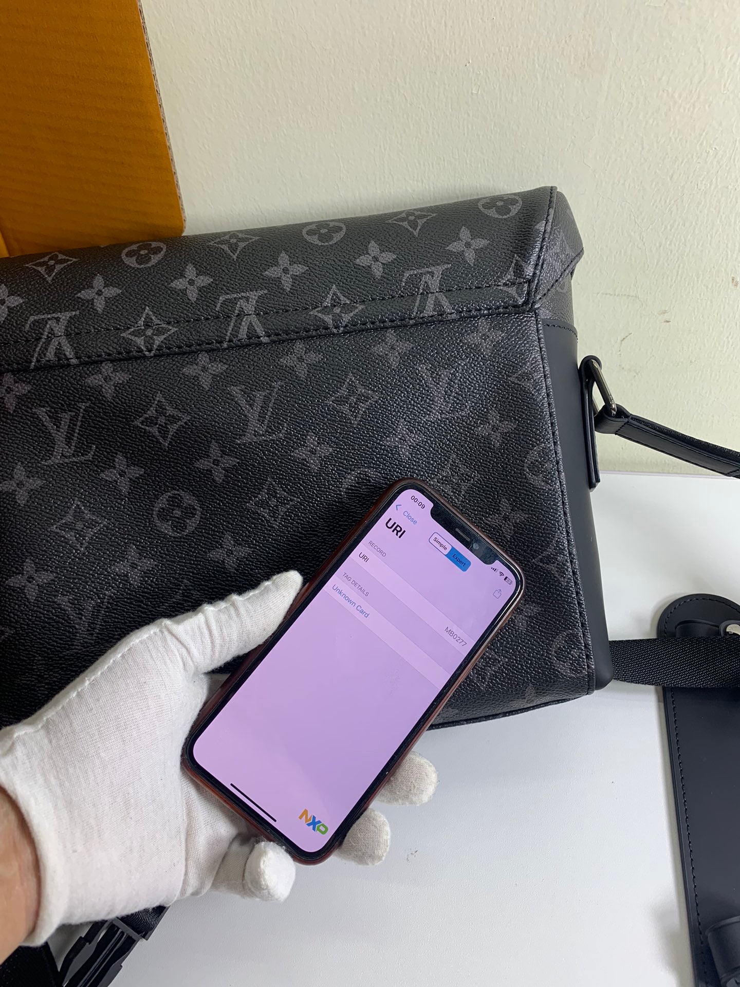 Louis Vuitton monogram bag with front zip and phone placed inside the opening