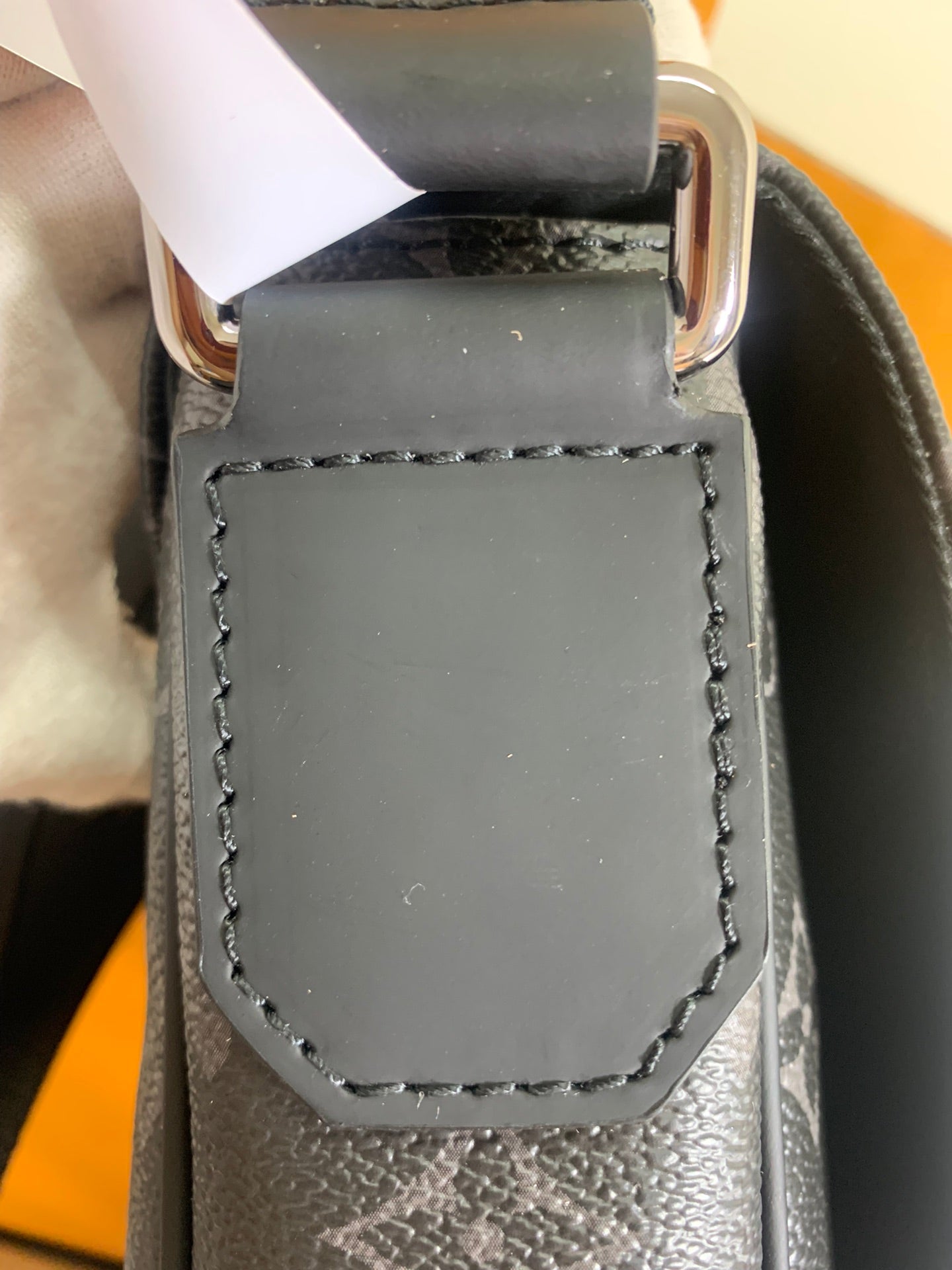 Louis Vuitton crossbody bag strap keeper with gray leather and silver buckle.
