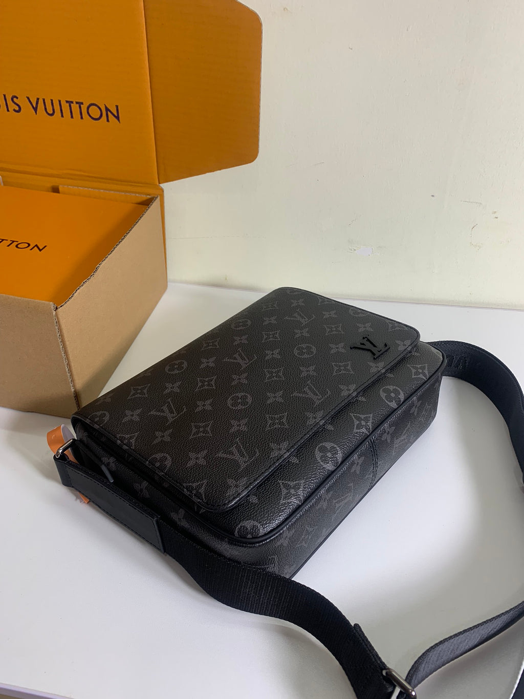 Louis Vuitton monogram crossbody bag with flap, dark gray pattern, black strap.