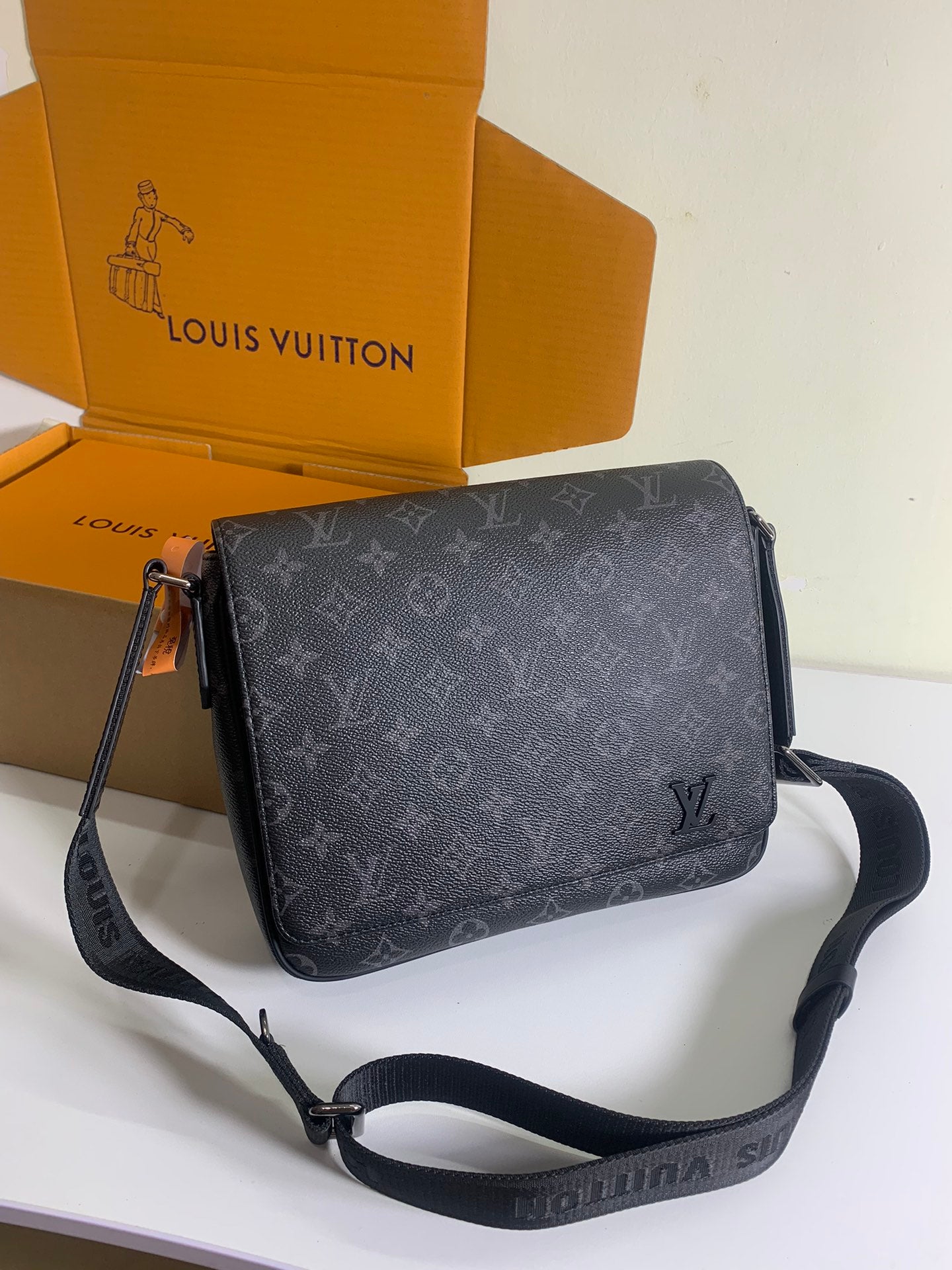 Louis Vuitton monogram crossbody bag in dark gray with adjustable strap.