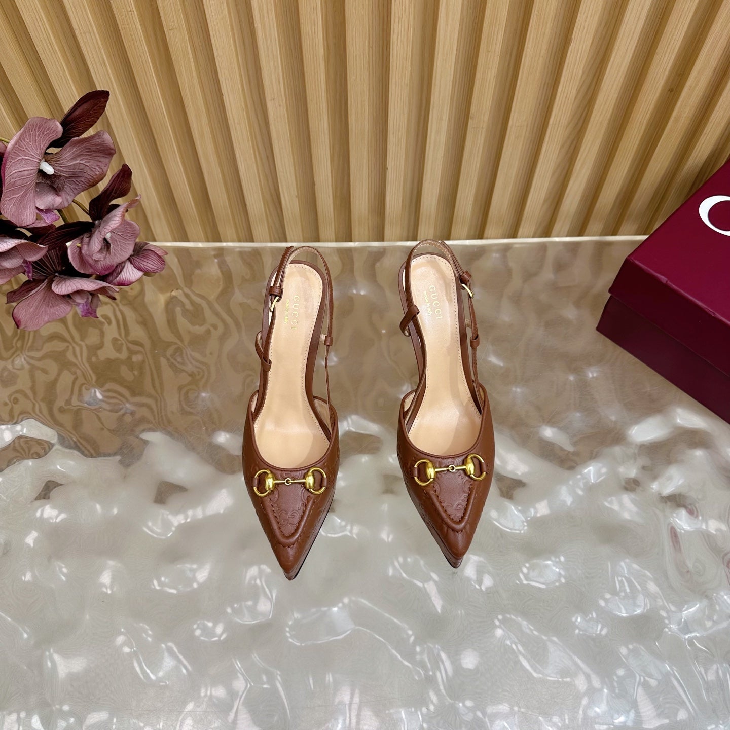Brown Gucci heeled mules with slingback strap and gold ring buckle, rear view