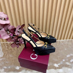 Black slingback stiletto heels with gold hardware and pointed toe