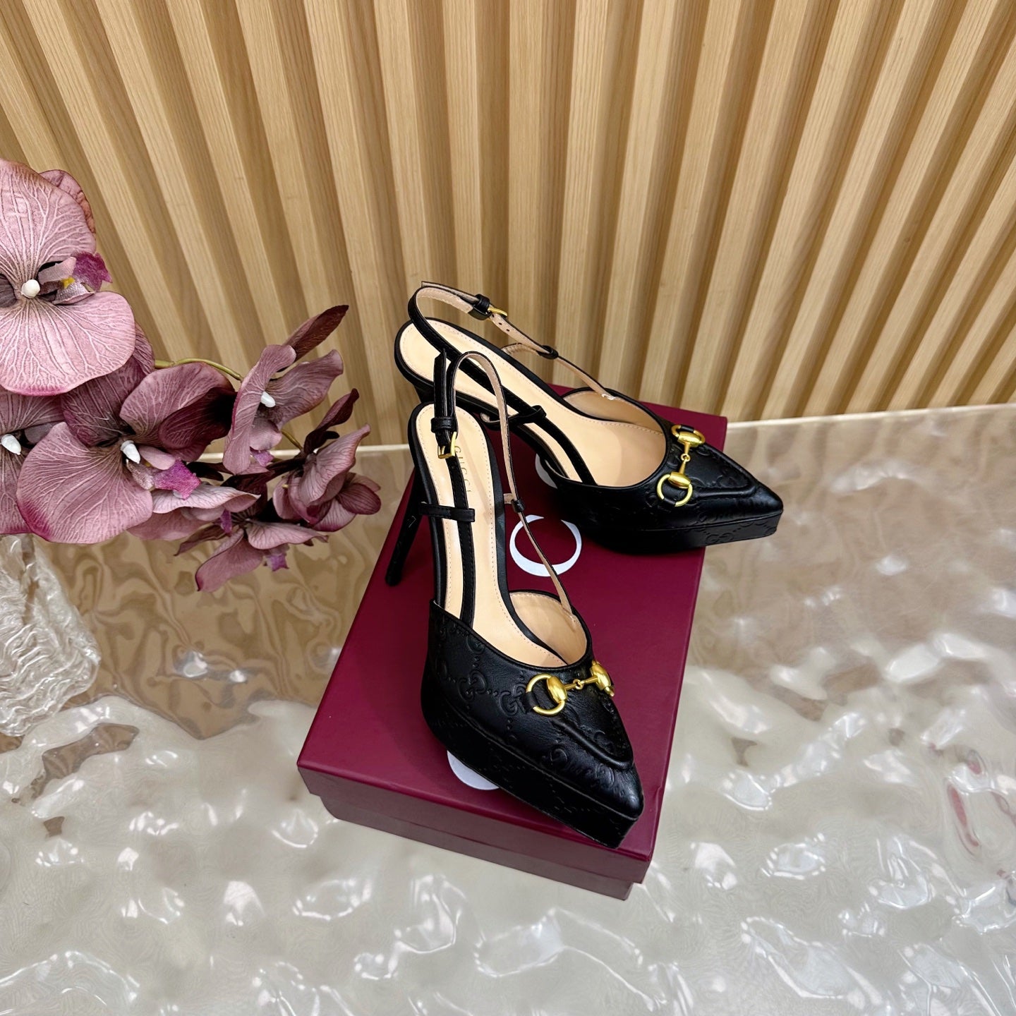 Black slingback stiletto heels with gold buckle detail and ankle strap