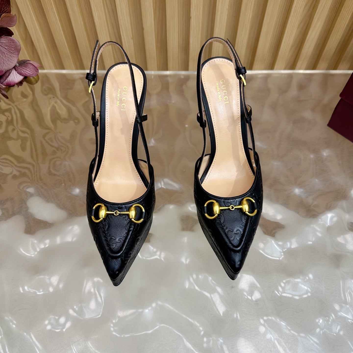 Black slingback heels with gold ring buckle and thin stiletto heel