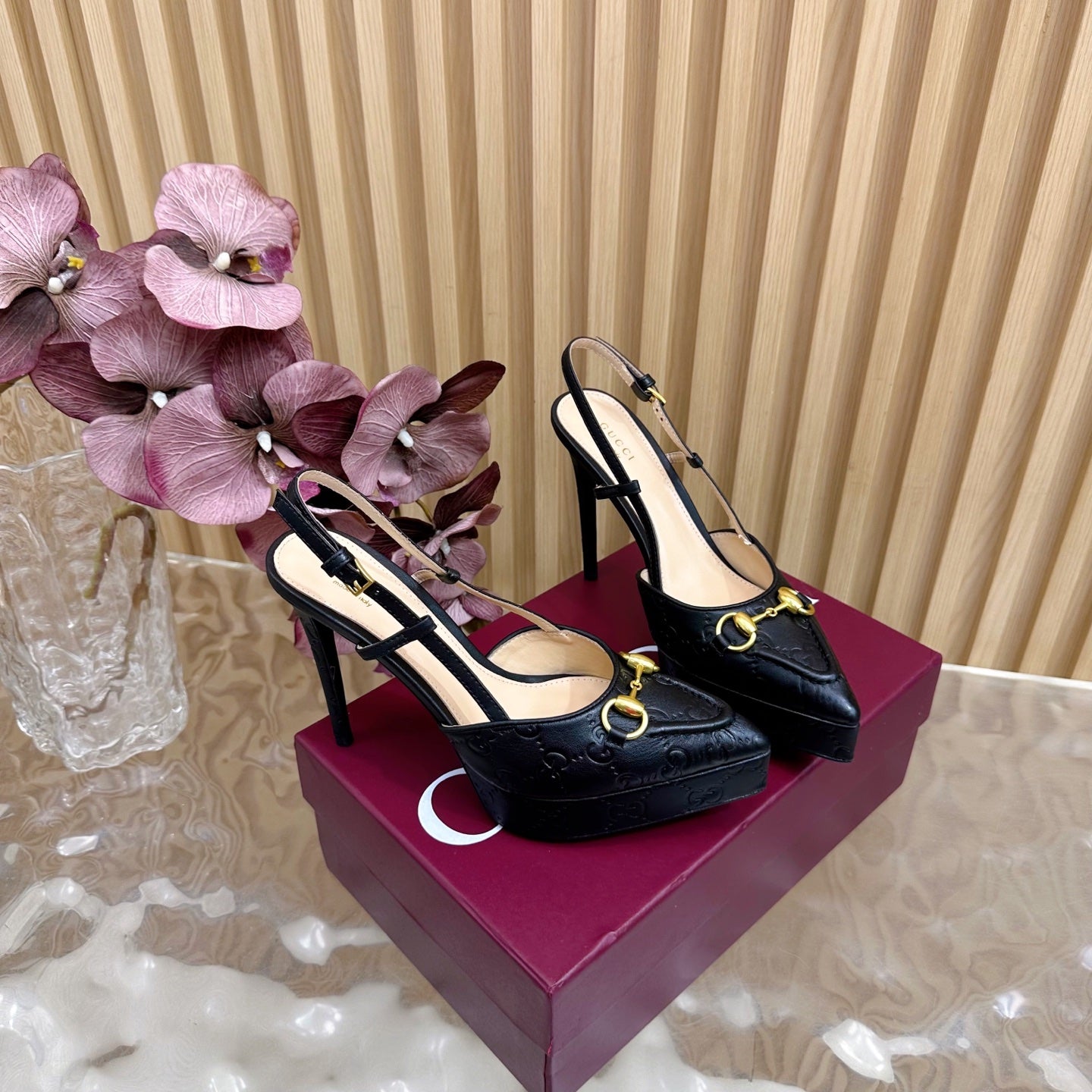 Pair of black slingback stiletto heels with gold hardware and high heel