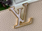 Louis Vuitton gold monogram emblem on white textured leather bag