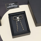 Chain charm necklace with round chain links, floral centerpiece, and two dangling chain tassels