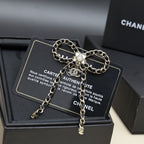 Chain charm necklace with floral pendant and dangling chain drops on a black display card