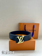 Dark blue leather belt with LV buckle on display next to the box